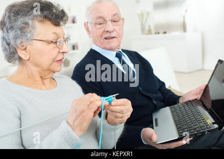 Uomo anziano utilizzando laptop, Maglieria Donna Foto Stock
