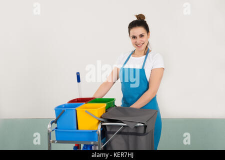Ritratto di felice bidello femmina con apparecchiature per la pulizia Foto Stock