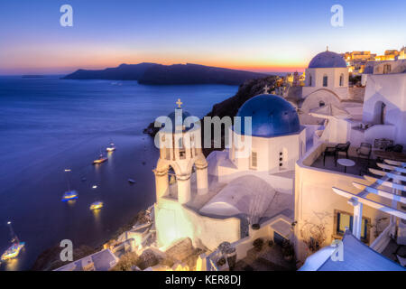 Greco tradizionale villaggio di Oia al tramonto, isola di Santorini, Grecia. Foto Stock