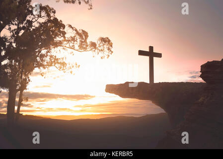 Gesù Cristo sulla cima della scogliera su sfondo al tramonto Foto Stock