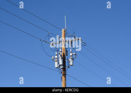 Le linee elettriche di alimentazione con interruttori di circuito di potenza e antenna sul nuovo polo di legno Foto Stock