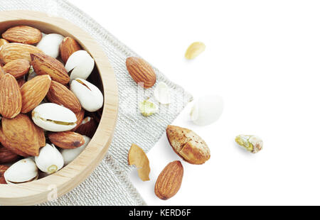 Un assortimento di mandorle in una ciotola su sfondo bianco. Foto Stock