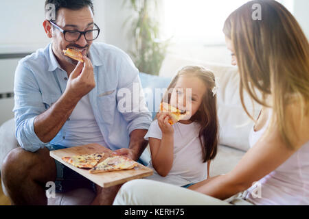 Felice Condivisione in famiglia pizza insieme a casa Foto Stock