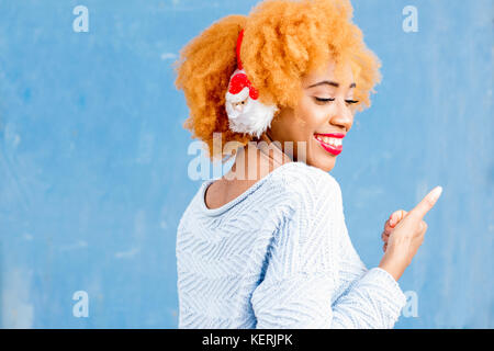 Colorato ritratto di una donna africana in cuffie di natale Foto Stock