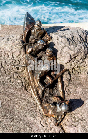 Una piccola scultura in bronzo di salvavita su una roccia lungo la passeggiata dalla spiaggia di Bondi a Coogee, Sydney Australia New South Wales. Foto Stock