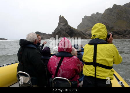 Visualizzazione del Gower da una barca, un piccolo gruppo di persone foto e ammirare la costa Knave dalla parte anteriore di una nervatura Foto Stock