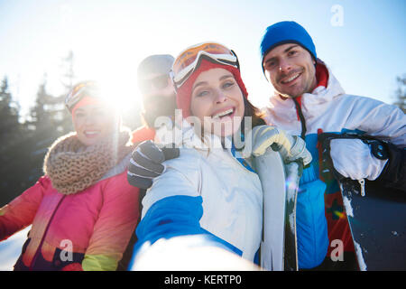 Il gruppo di quattro felici gli appassionati di snowboard Foto Stock