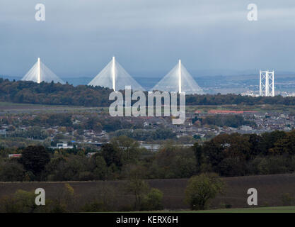 Una vista del nuovo Queensferry Crossing e Ponte di Forth Road illuminata dal sole con Kirkliston villaggio in primo piano su una noiosa giornata di ottobre. Foto Stock