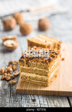 Torta con noci e miele sul vecchio tavolo in legno. Foto Stock