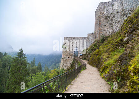 Vista generale del centro storico di Zil Castello sulla cima di una collina con grandi pareti in pietra tra alberi di pino e nebbioso sky. Zil castello fu costruito in Byzantyne pe Foto Stock