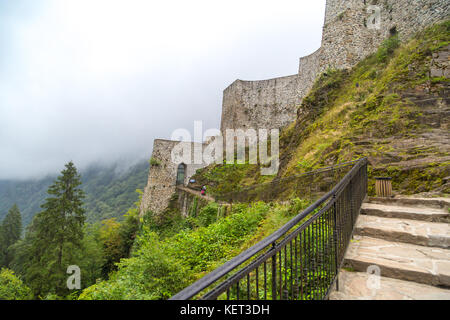 Vista generale del centro storico di Zil Castello sulla cima di una collina con grandi pareti in pietra tra alberi di pino e nebbioso sky. Zil castello fu costruito in Byzantyne pe Foto Stock