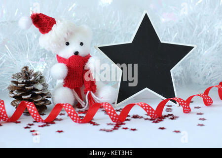 Orso polare indossando un cappello e una sciarpa rossa per la festa di natale decorazione con un messaggio vuoto ardesia Foto Stock