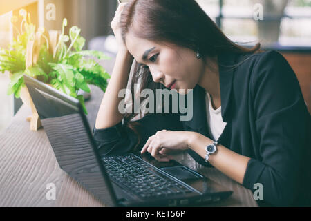 Asian imprenditrice serio circa il lavoro svolto fino a quando il mal di testa,soft focus Foto Stock