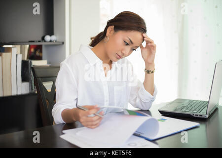 Asian imprenditrice e donne studente serio circa il libro di lettura e il duro lavoro fatto fino a quando il mal di testa Foto Stock