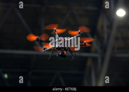 Sfocata flying drone con la fotocamera nella notte Foto Stock