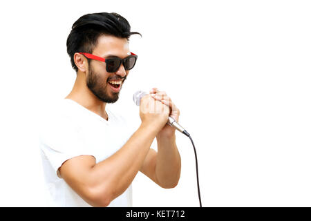 Asian uomo bello con un baffi, sorridente e Cantare al microfono isolati su sfondo bianco ,soft focus Foto Stock