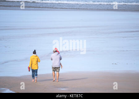 Turisti che camminano su una spiaggia - una famiglia di vacanzieri che camminano sulla spiaggia di Fistral a Newquay, Cornovaglia. Foto Stock