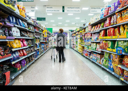 Shopping in un supermercato Morrisons - shopper camminando per un corridoio in un supermercato Morrisons. Foto Stock