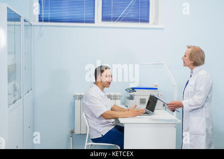 Gioiosa medici di medicina generale a discutere il loro lavoro in ufficio dell'ospedale. Foto Stock