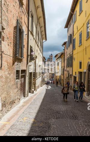 Un viale medievale della città di collina con piazza Duca Federico sullo sfondo urbino provincia di pesaro marche italia Europa Foto Stock