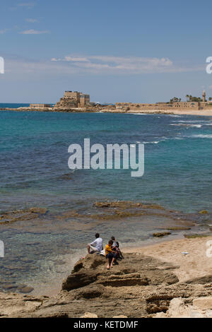 I ragazzi guardano oltre il mare mediterraneo per le antiche rovine di Cesarea, Israele. Foto Stock