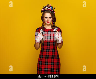 Colorato halloween. Ritratto di giovane donna in stile messicano costume di halloween isolato su giallo Foto Stock