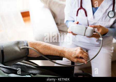 Irriconoscibile visitatore di salute e un senior donna durante home vis Foto Stock