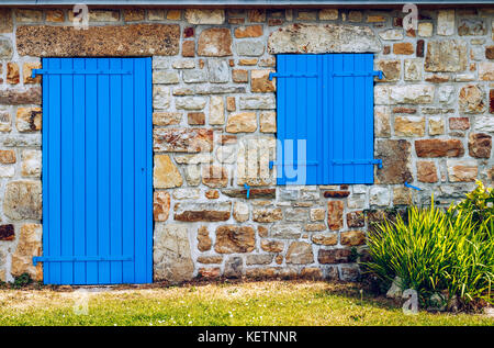 Blu Vintage porta e finestra sulla facciata di un antico casolare in pietra. Foto Stock