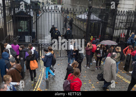 Polizia armata guardia alle porte di Downing Street, la residenza ufficiale e gli uffici del Primo Ministro britannico Theresa Maggio, il 19 ottobre 2017, a Londra, in Inghilterra. Foto Stock