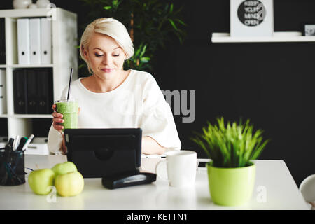Donna con smoothie chat online Foto Stock