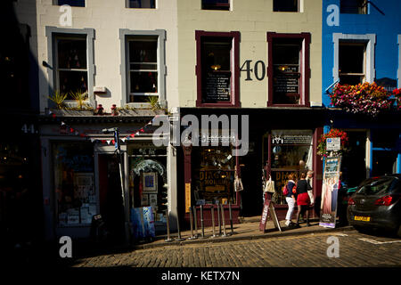 Centro storico di Edimburgo, Scozia Grassmarket ciottoli prua ovest che conduce fino a Victoria Street foderato con eleganti negozi indipendenti con Victoria Terrace abov Foto Stock