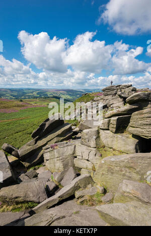 Tourist si fermò sulle rocce a higger tor vicino a hathersage nel parco nazionale di Peak District, Derbyshire, in Inghilterra. Foto Stock