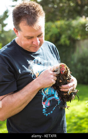 L'uomo con il suo pollo bantam pet Foto Stock