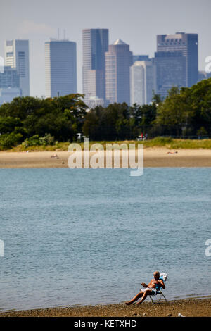 Boston Massachusetts New England America del nord Stati uniti d'America , sunbather alla costituzione Beach guardando l'Aeroporto Internazionale Logan e lo skyline della città Foto Stock