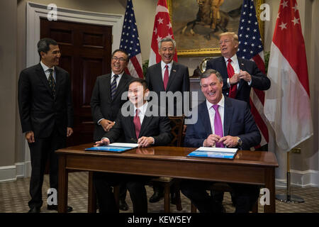 Il vicepresidente esecutivo della Boeing Kevin McAllister (C-R) e il CEO di Singapore Airlines Goh Choon Phong (C-L) insieme al presidente degli Stati Uniti Donald Trump (R) e Lee Hsien Loong (C) di Singapore partecipano a una cerimonia di firma per le vendite di aerei nella stanza Roosevelt alla Casa Bianca a Washington, DC, USA, 23 Ottobre 2017. L’incontro giunge meno di due settimane prima che il presidente Trump faccia un viaggio esteso nella regione Asia-Pacifico. Credito: Jim Loscalo/Pool via CNP /MediaPunch Foto Stock