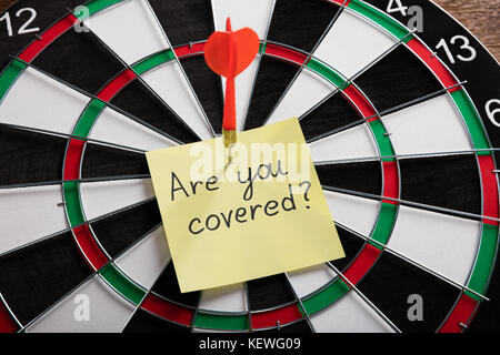 Freccia rossa di colpire sulla nota gialla che mostra Sei pronto concetto su Dartboard Foto Stock