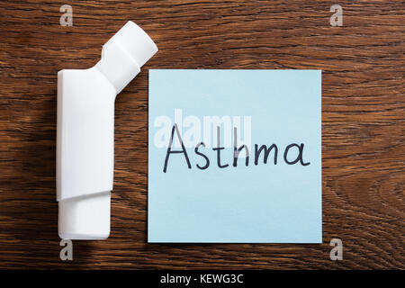 Concetto medico di asma con un inalatore sulla scrivania in legno Foto Stock