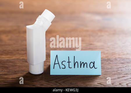 Concetto medico di asma con un inalatore sulla scrivania in legno Foto Stock