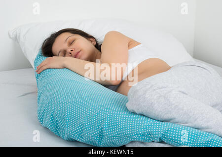 I giovani aspettano di donna che dorme sul letto nella sua camera da letto Foto Stock