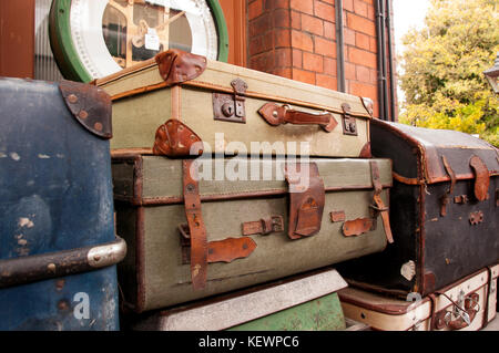 Bagagli vintage impilati su una stazione ferroviaria platform Foto Stock