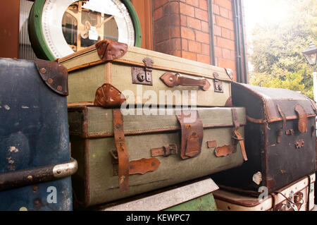 Bagagli vintage impilati su una stazione ferroviaria platform Foto Stock