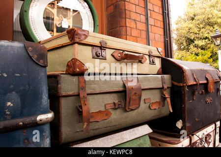 Bagagli vintage impilati su una stazione ferroviaria platform Foto Stock