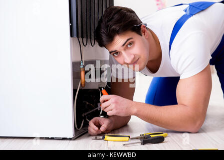 Repairman contraente riparazione frigorifero nel concetto di DIY Foto Stock