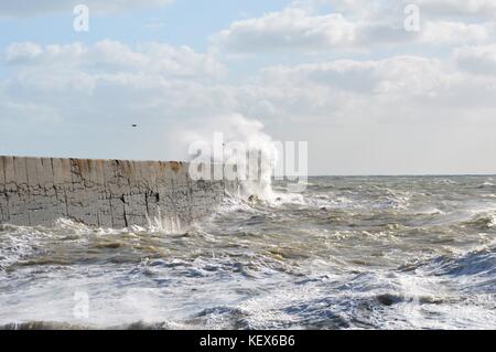 Mare mosso che colpisce la parete del porto lungo la costa sud dell'inghilterra. Foto Stock