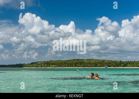 Coppia bagno e foto con bastone selfie in paradiso acque del sud Bahia, Brasile Foto Stock