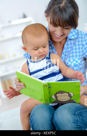 Donna flipping picture book con il bambino Foto Stock