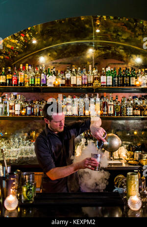 Un barman rende un cocktail presso un elegante bar in Seattle's Capital Hill quartiere. Foto Stock