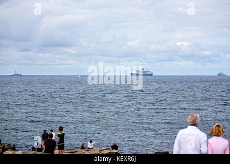 La Queen Mary 2 passando Groix Island, sul suo modo di Saint Nazaire per l'inizio del centenario Transat il ponte 2017, una storica gara transatlantica tra lei e una flotta di gigante trimarans. Foto Stock