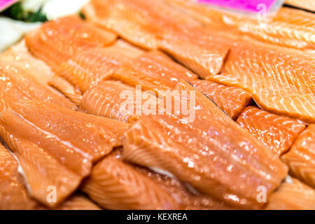 Close up di filetti di salmone sparsi su ghiaccio su un pesce monger del mercato in stallo nello Yorkshire, Inghilterra, Regno Unito Foto Stock