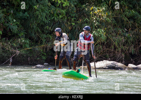 Fotografia dei due uomini la navigazione sul fiume stand-up paddleboards, Amazzonia peruviana, Parco Nazionale del Manu, Perù Foto Stock